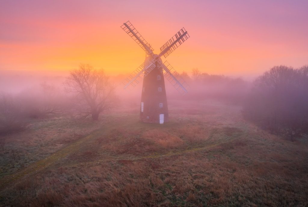 Billingford Windmill surrounded by mist at sunrise, Norfolk, England