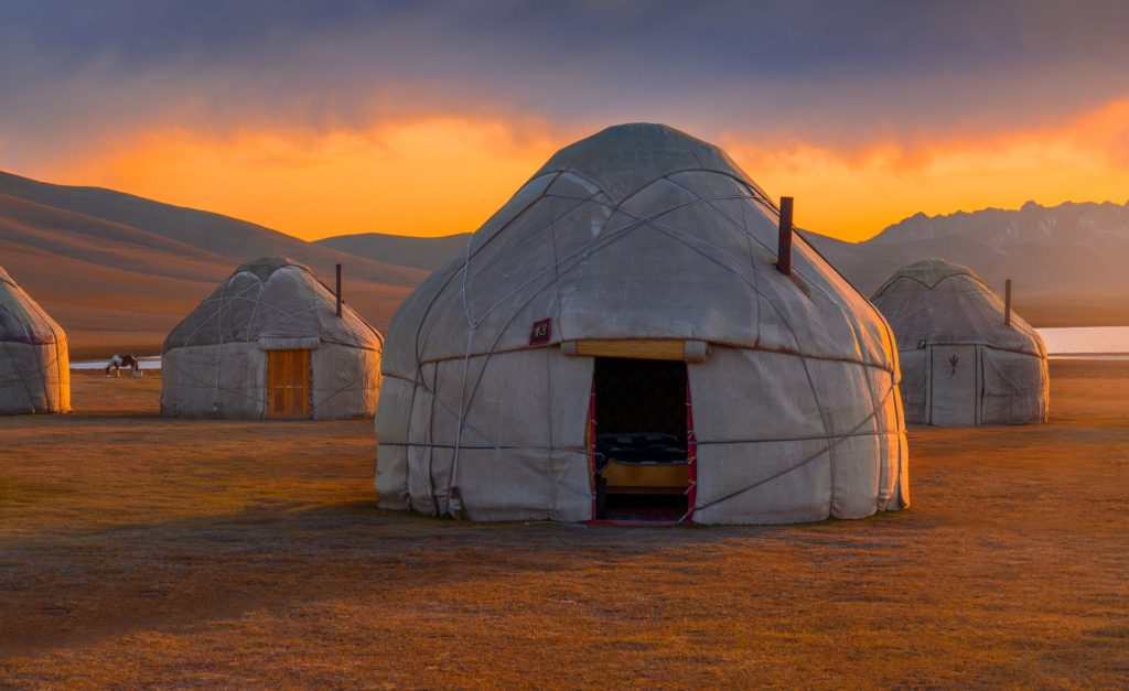 Yurt camp at sunset in Kyrgyzstan's mountainous landscape