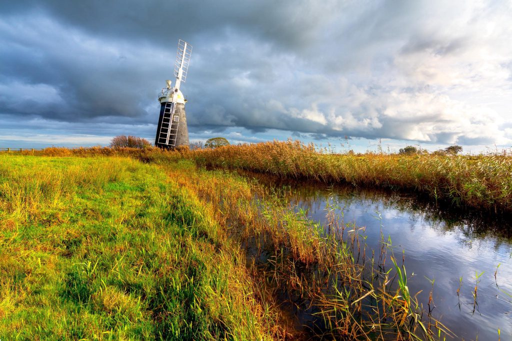 Halvergate Marsh windmill under dramatic stormy skies, Norfolk, England