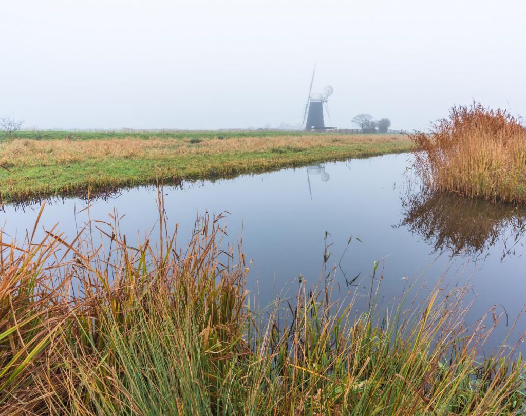 Windmill Halvergate Marshes, Norfolk, amid a foggy morning