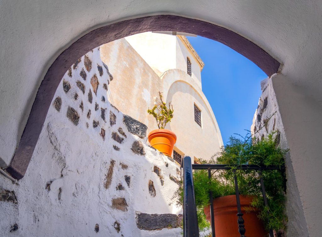 Charming alleyway with potted plants in Santorini, Greece