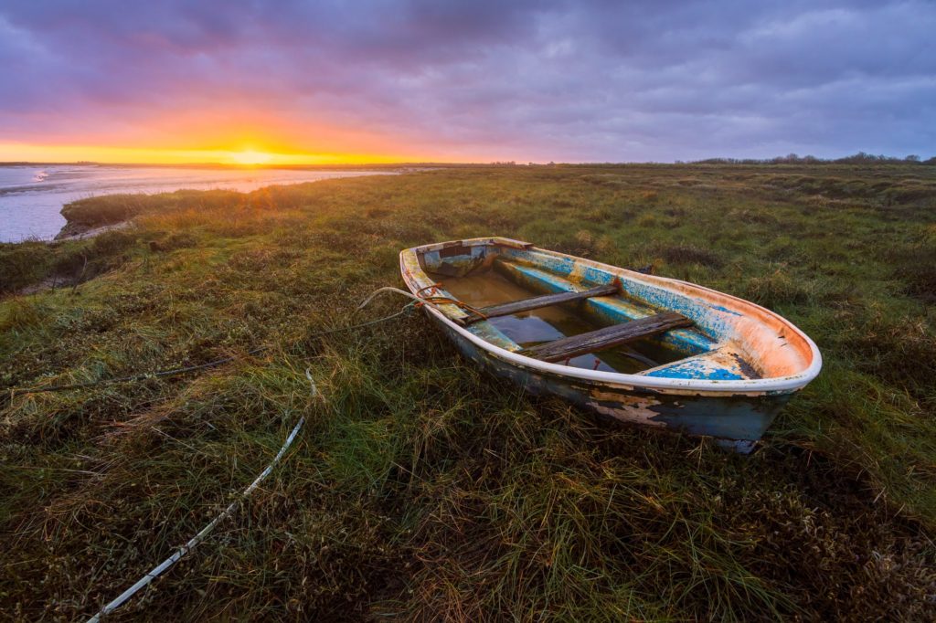 Barlinghall Creek at sunrise with a stranded boat, Essex, England
