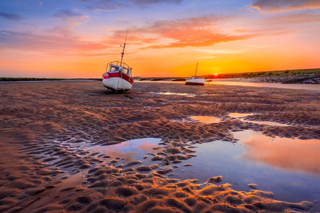 Low tide at sunrise with boats, Burnham Overy Staithe, Norfolk, England