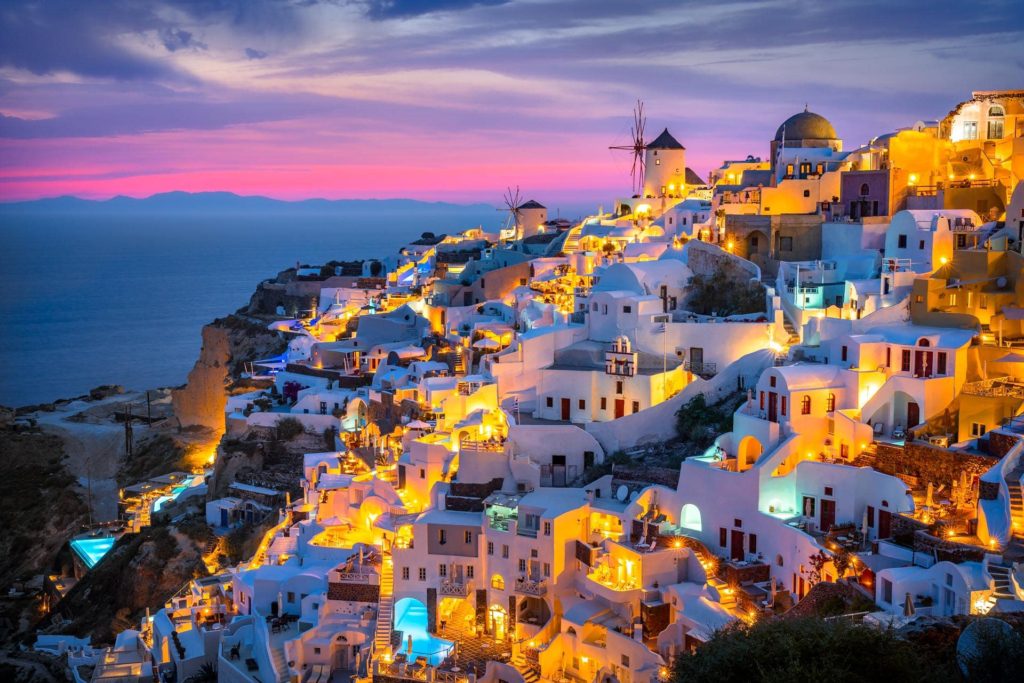 Twilight view of Oia's white buildings and windmill, Santorini, Greece