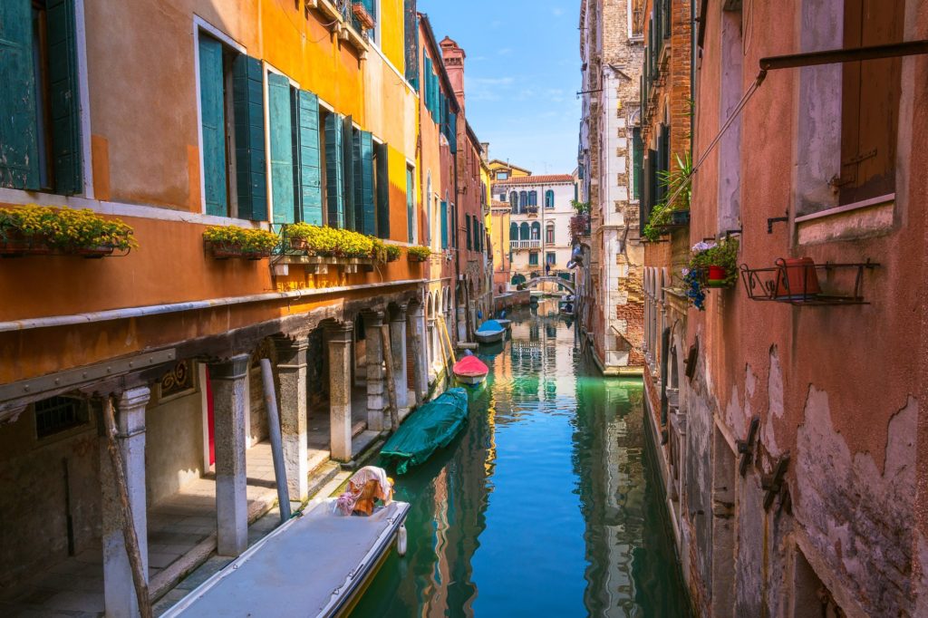 Vibrant buildings lining a sunny canal in Venice, Italy