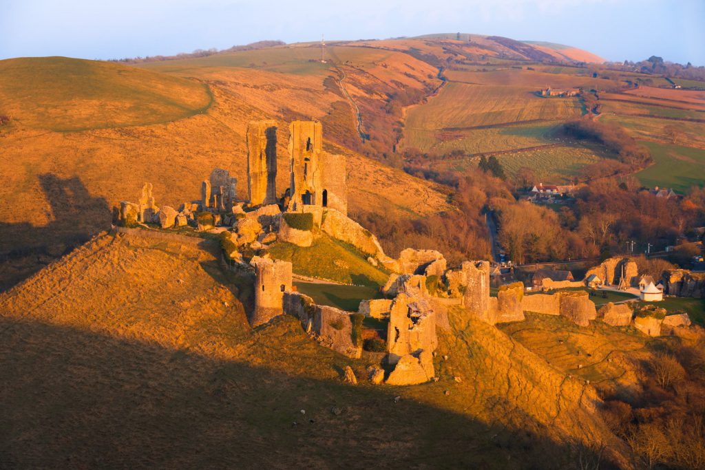 Corfe Castle ruins bathed in warm sunset light, Dorset, England