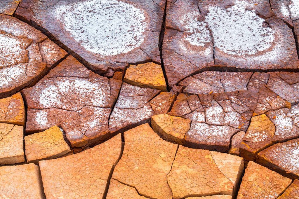Mud cracks in vibrant orange and brown hues, Death Valley, USA