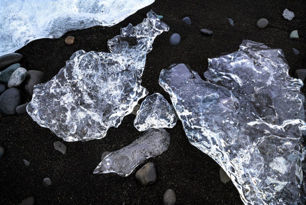 Clear ice formations on black sand at Diamond Beach, Iceland