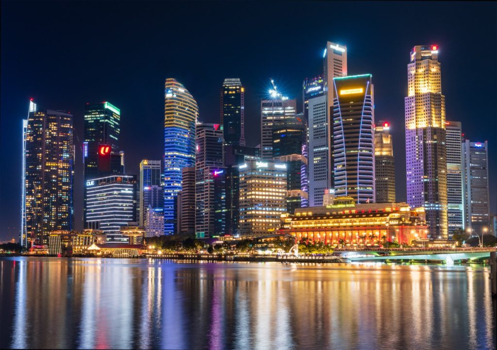 Downtown Singapore skyline illuminated at night with reflections in water