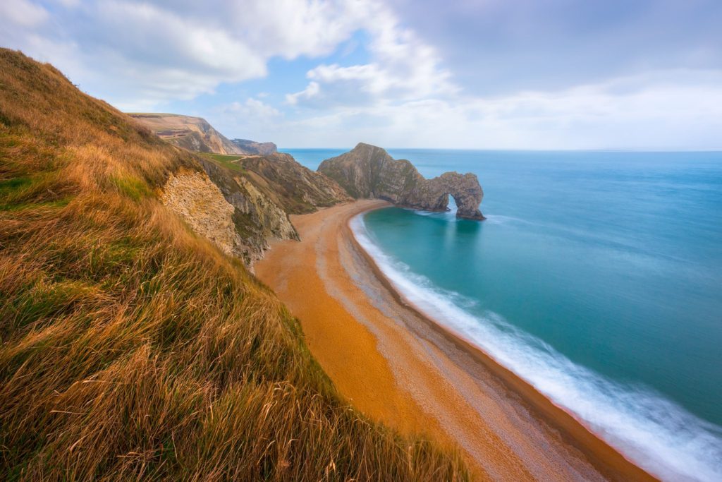 Durdle Door rock formation and sandy beach in Dorset, England