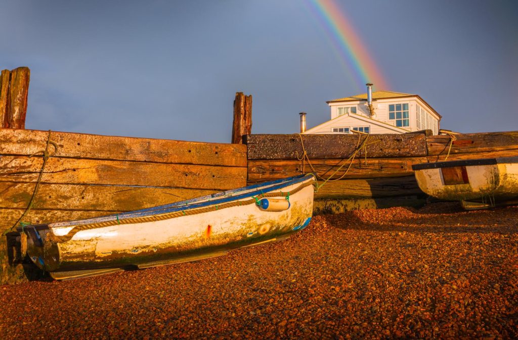 Ferry boats on a pebbled beach with a rainbow, Felixstowe Ferry, Suffolk