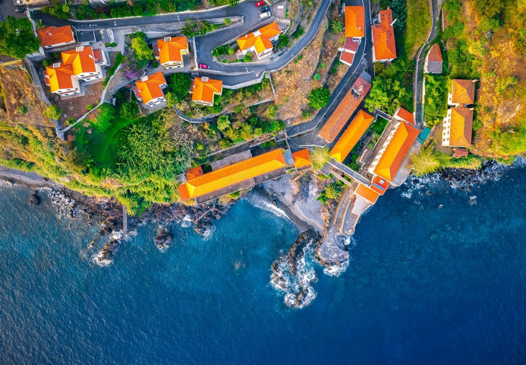 Aerial view of coastal buildings and rocky shoreline in Funchal, Madeira, Portugal