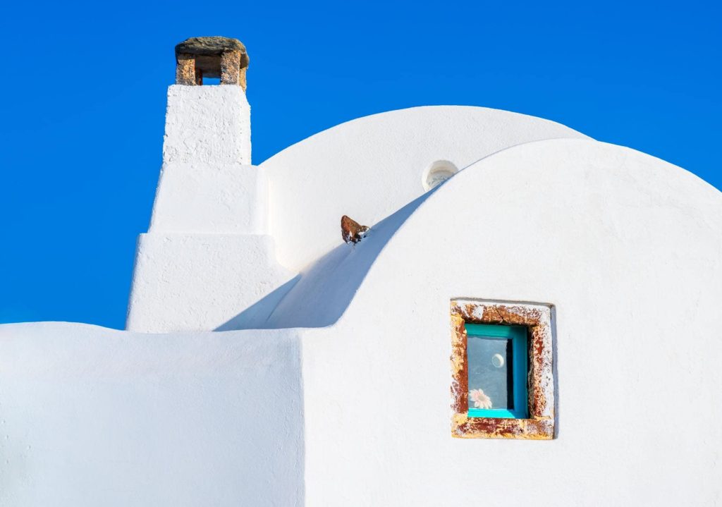 Whitewashed buildings with colourful windows in Santorini, Greece