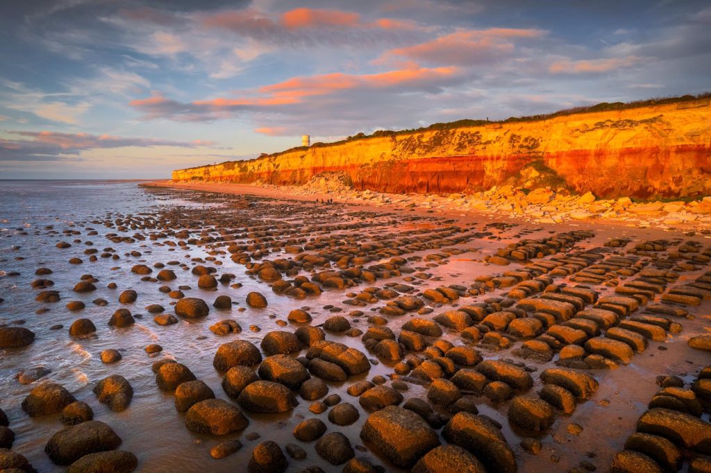 Hunstanton beach at sunset with rocky shoreline and cliffs, England
