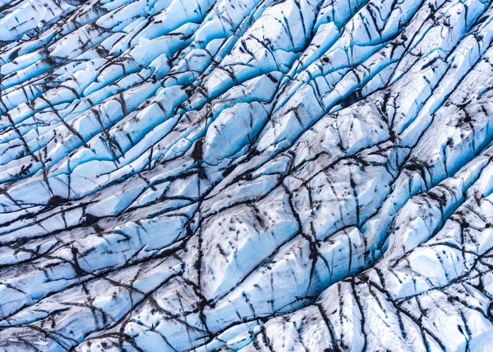 Aerial view of a glacier's blue and white ice formations, Iceland