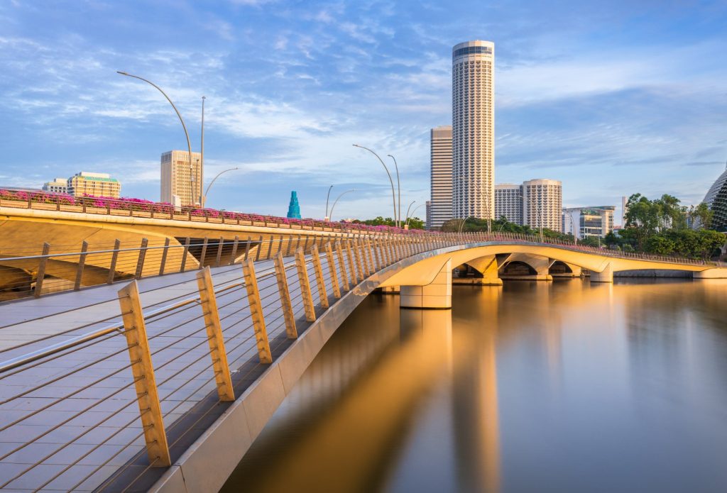 Jubilee Bridge arching over water with city skyline in Singapore