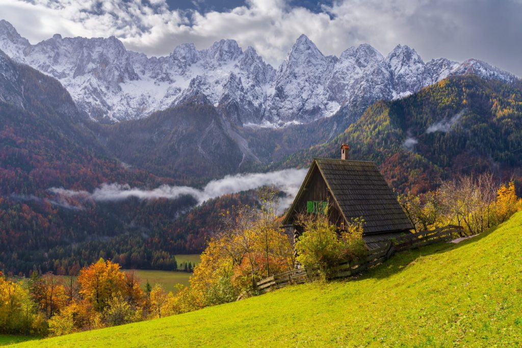 Julian Alps with autumn foliage and a rustic cottage, Slovenia