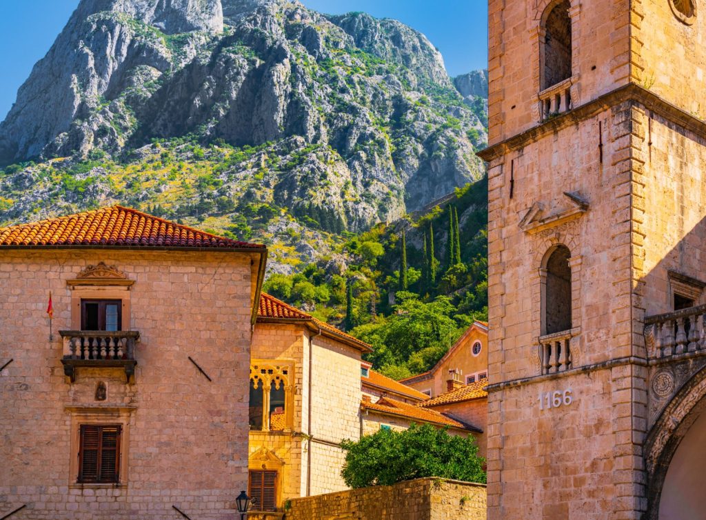 Sunny old town buildings with mountains in Kotor, Montenegro