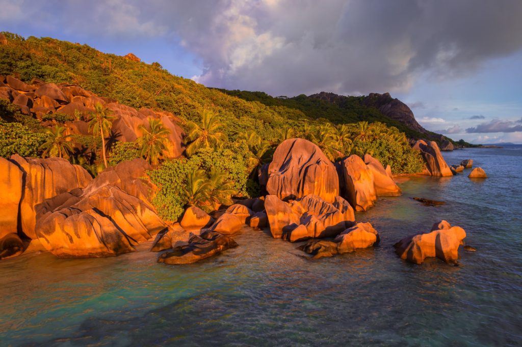 Dramatic light illuminating granite boulders, La Digue, Seychelles