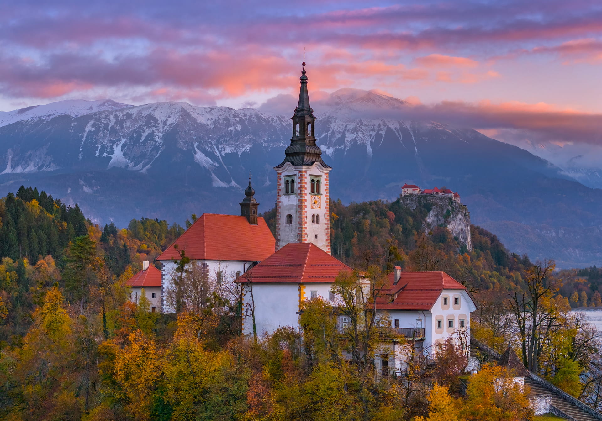 Church on Lake Bled surrounded by autumn foliage at sunrise, Slovenia