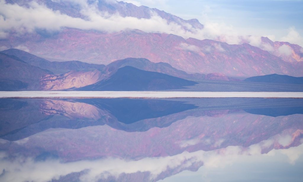 Serene reflection of mountains in Lake Manly, Death Valley, USA