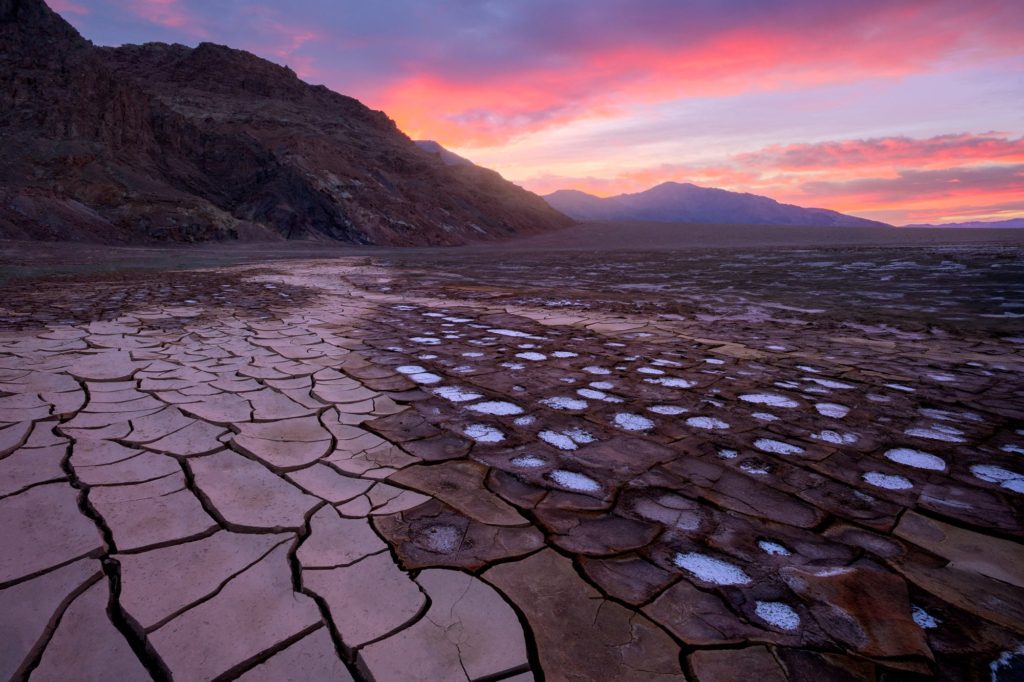 Mud cracks illuminated by sunrise in a desert landscape