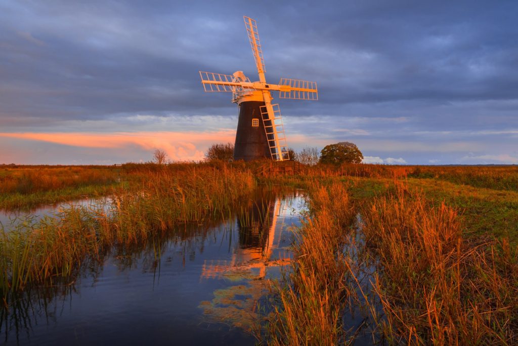 Windmill at sunset surrounded by autumnal landscape, Norfolk, England