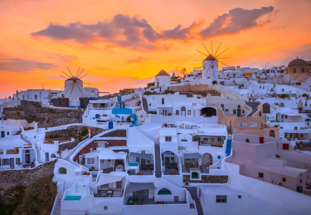 Windmills at sunrise overlooking Oia, Santorini, Greece