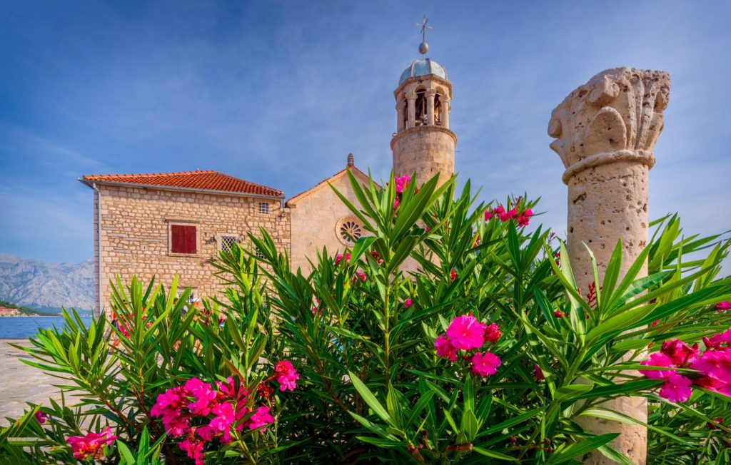 Our Lady of the Rocks church surrounded by vibrant flowers, Kotor, Montenegro