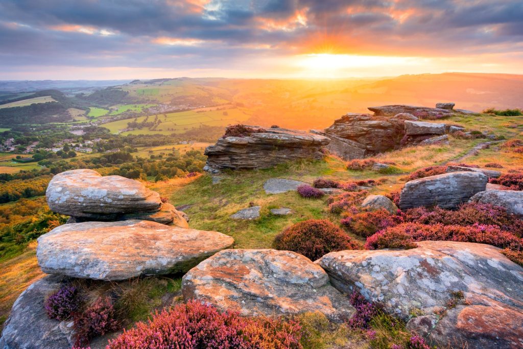 Sunset over Curbar Edge, Peak District, England with rocky outcrops and heather