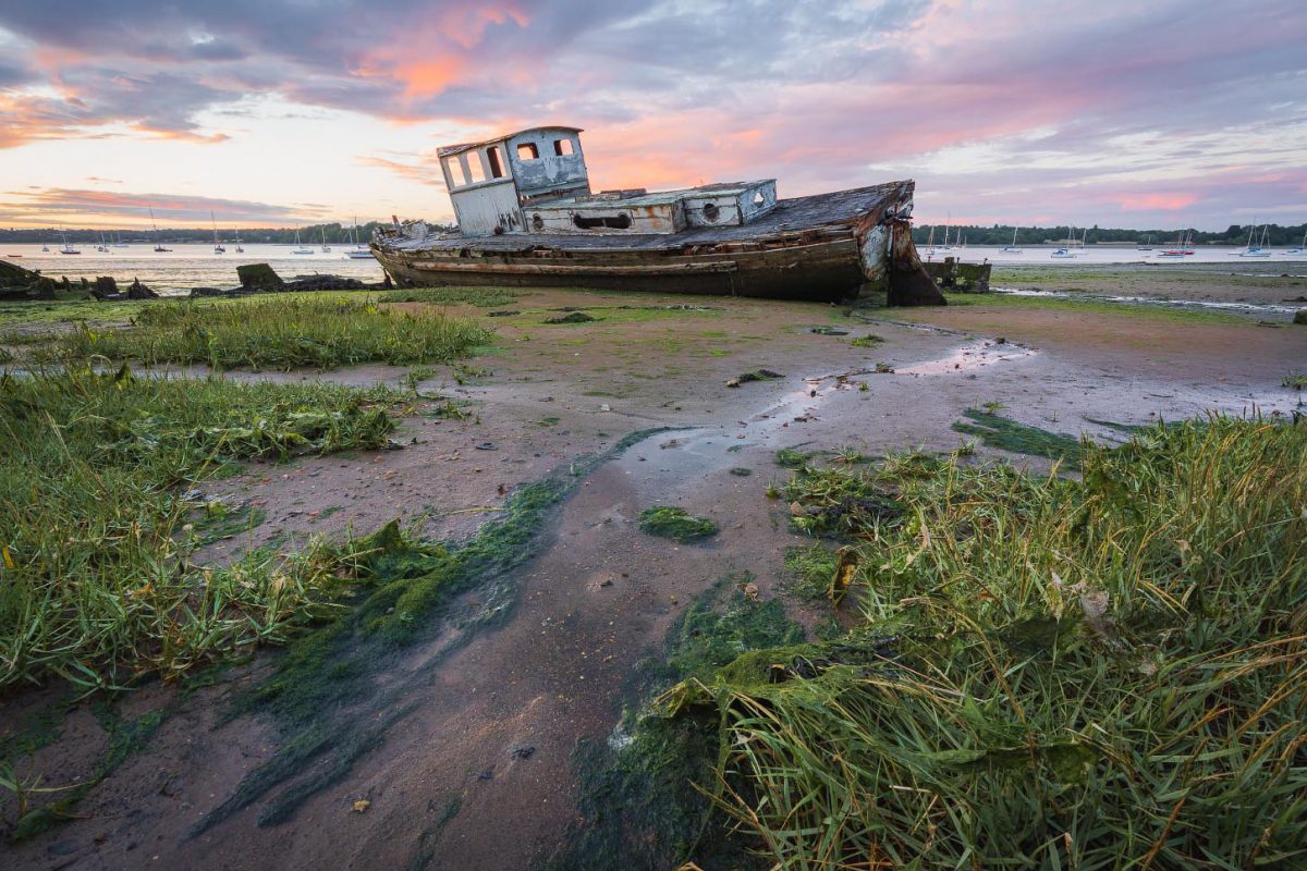 Derelict boat on the shore at Pin Mill, Suffolk, with beautiful sunset in the background