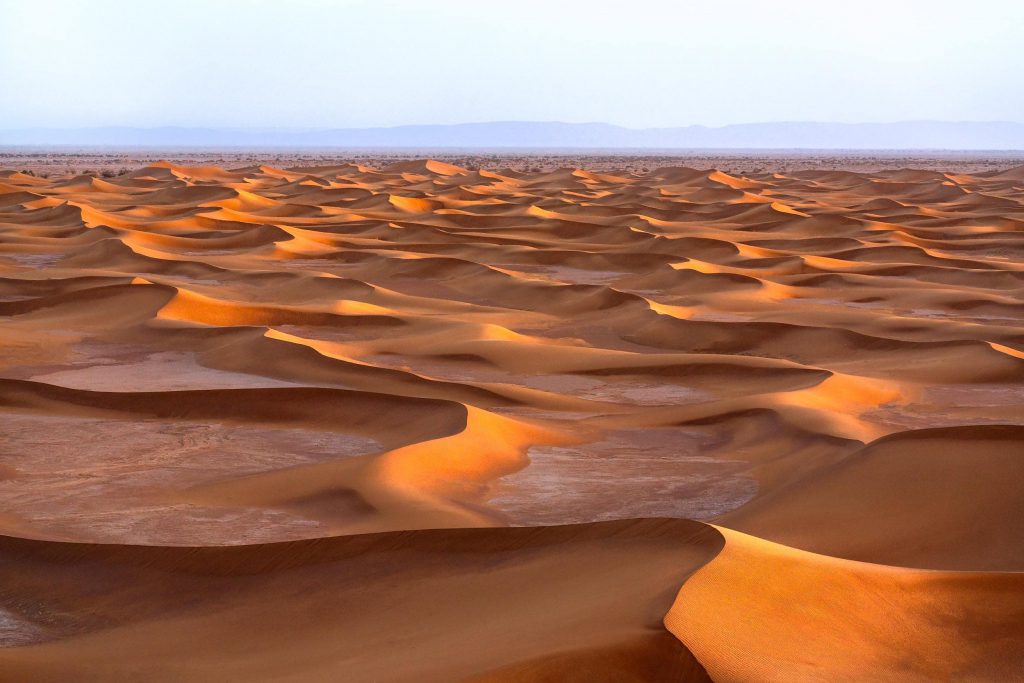 Sandy dunes illuminated by sunset in the Sahara Desert, Morocco