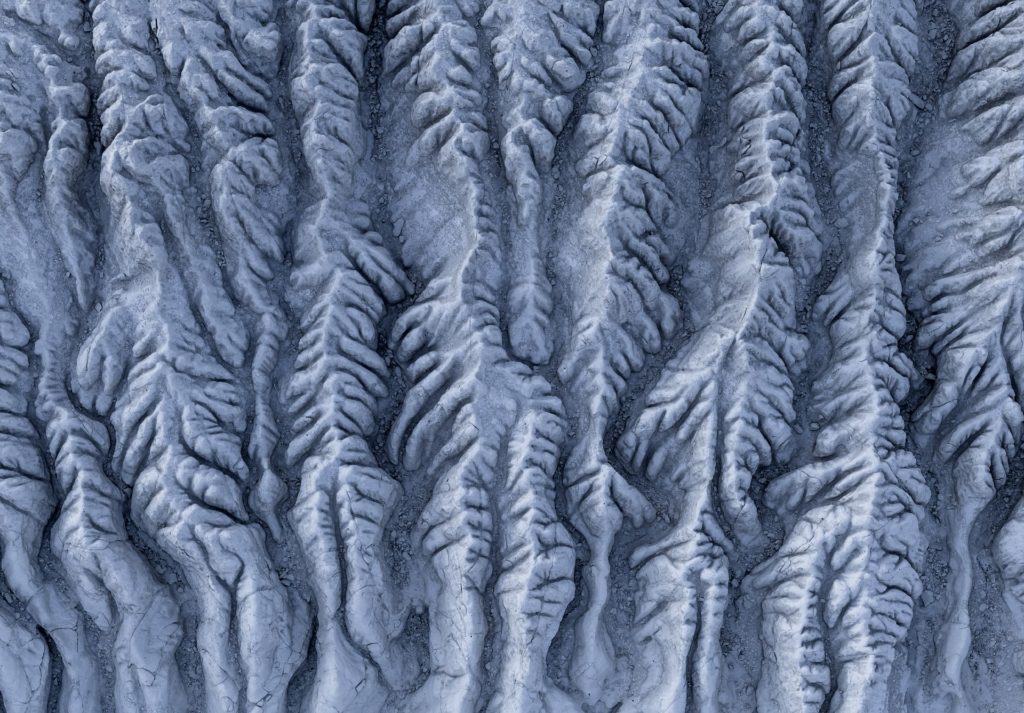 Intricate salt flat formations in a textured grey landscape