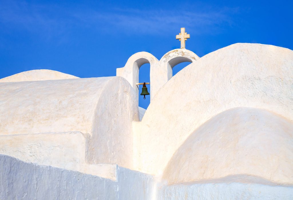 Bell tower with a cross against a blue sky, Santorini, Greece