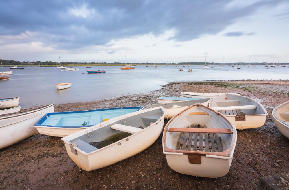 Boats on the shore at Waldringfield, Suffolk, with stormy clouds in the background