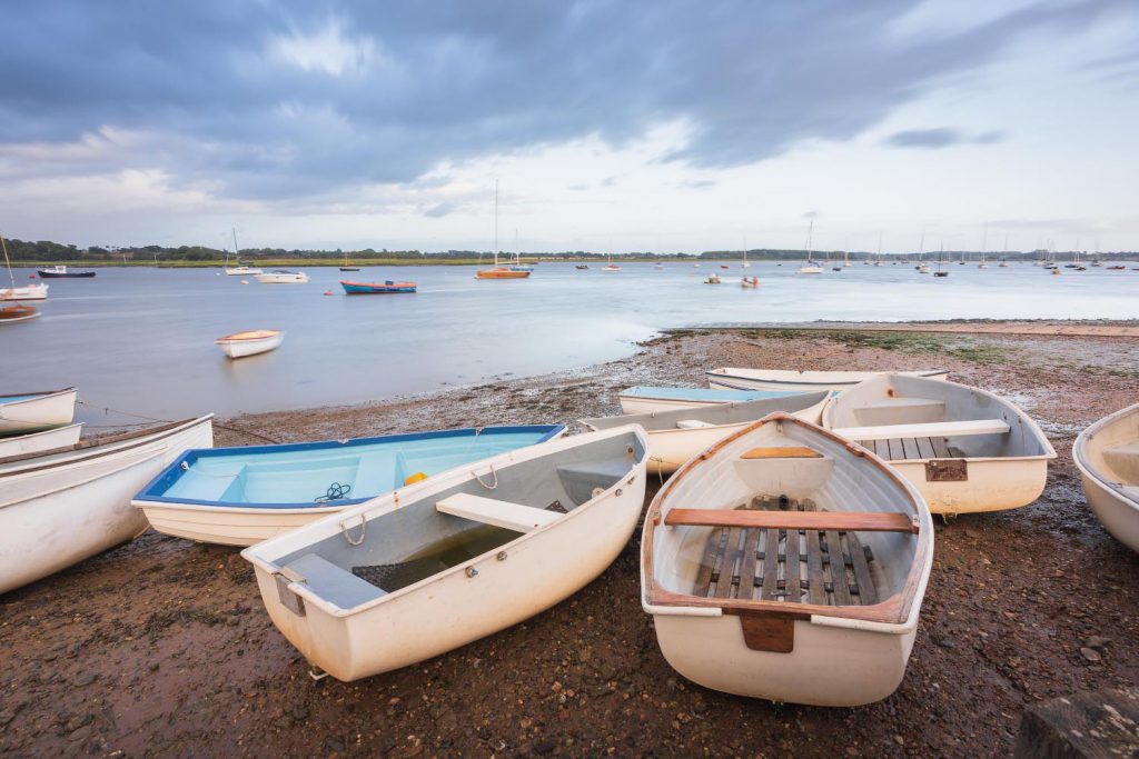 Boats on the shore at Waldringfield, Suffolk, with stormy clouds in the background