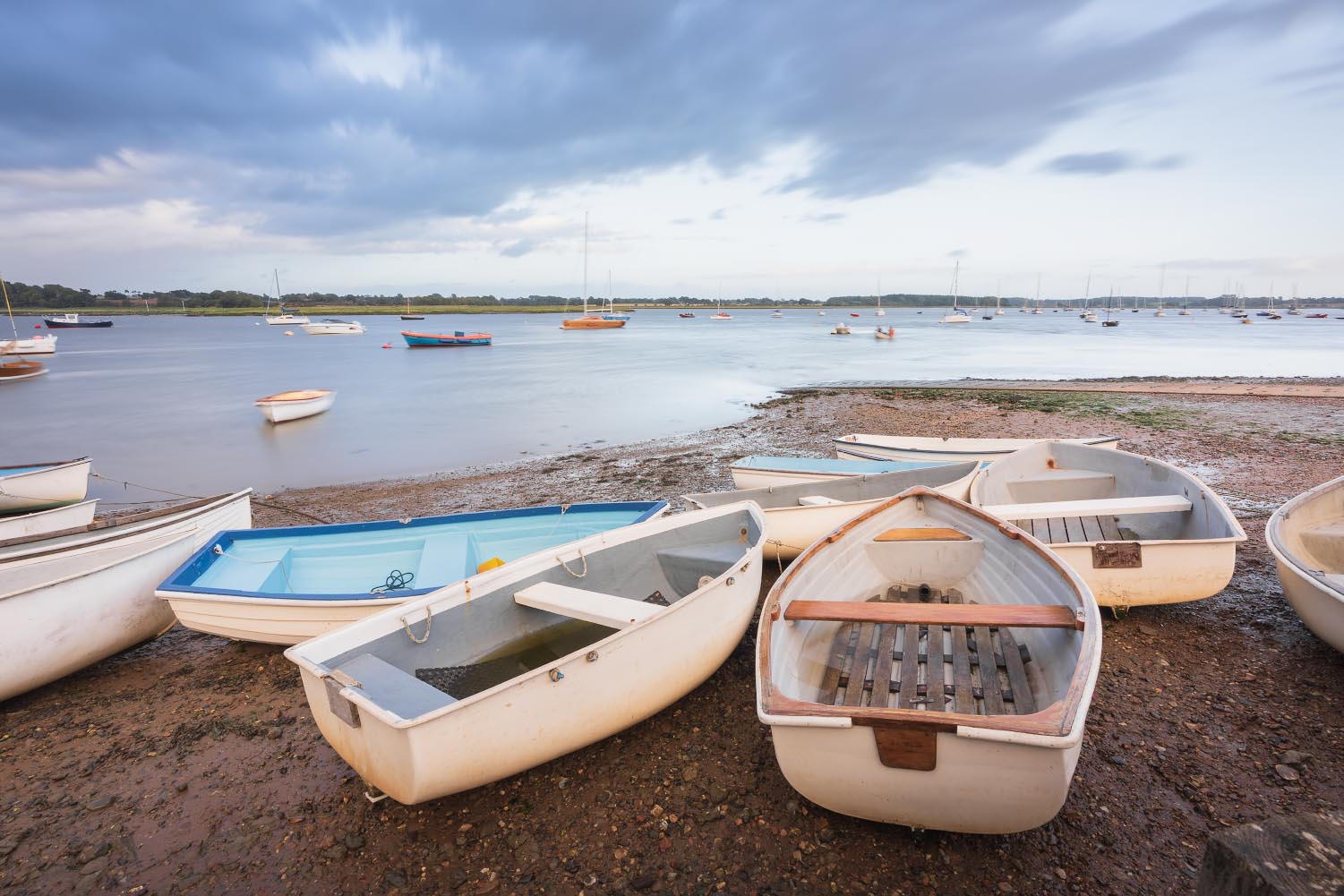 Boats on the shore at Waldringfield, Suffolk, with stormy clouds in the background