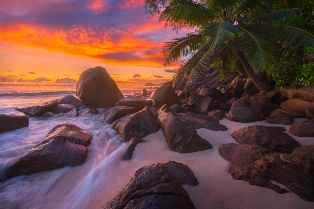Vibrant sunset over Anse Takamaka's rocky shoreline, Seychelles