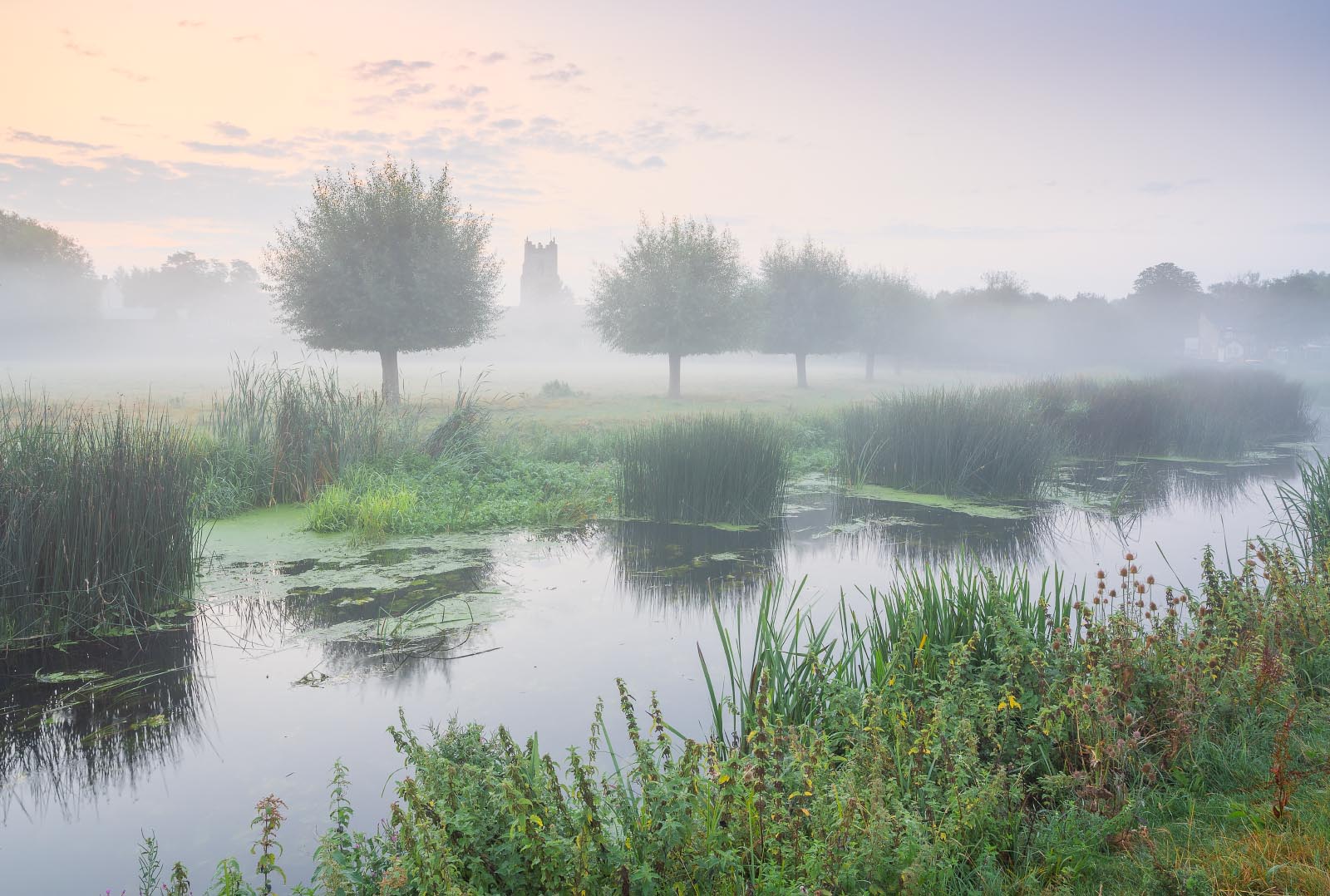 Sudbury water meadows with mist and fog with the church in the distance