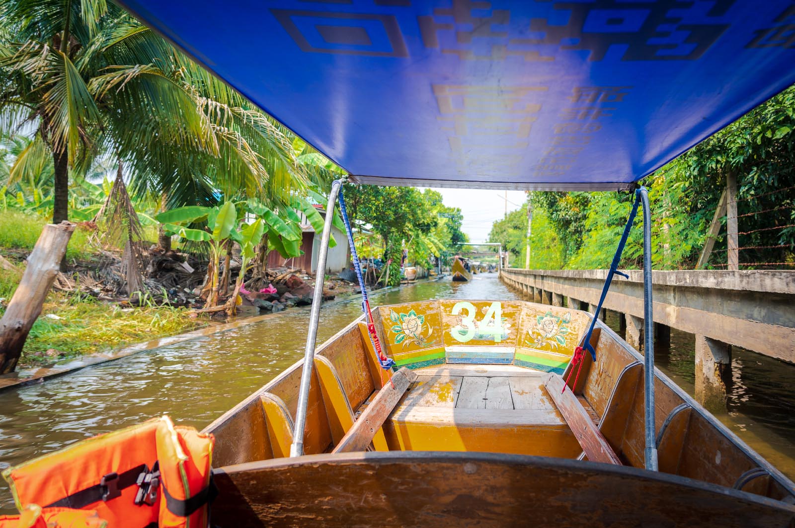 view from a boat going down a canal in Thailand