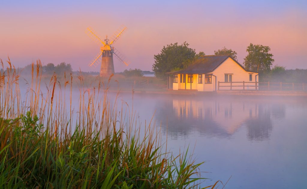 Thurne Mill at sunrise with mist and reflections, Norfolk, England