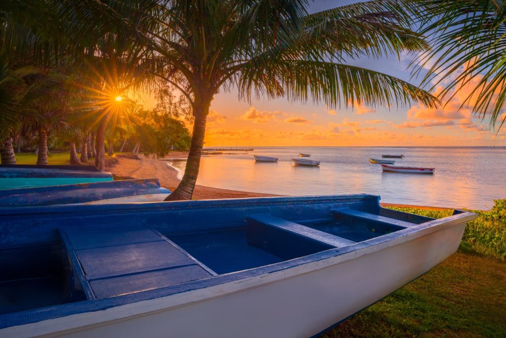 Beach at sunrise with boats and palm trees, Mauritius