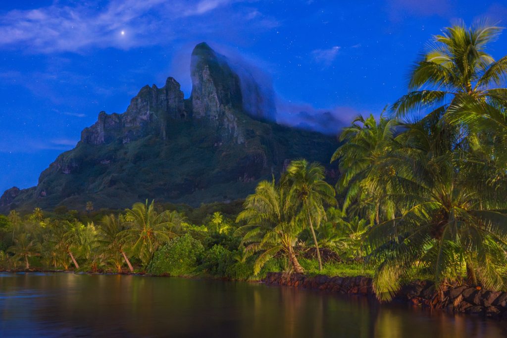 Starry sky over lush greenery and mountains in Bora Bora, French Polynesia