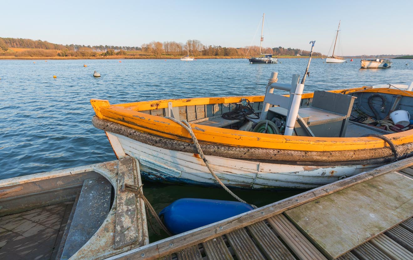 Moored boat on the River Deben catching the evening sun