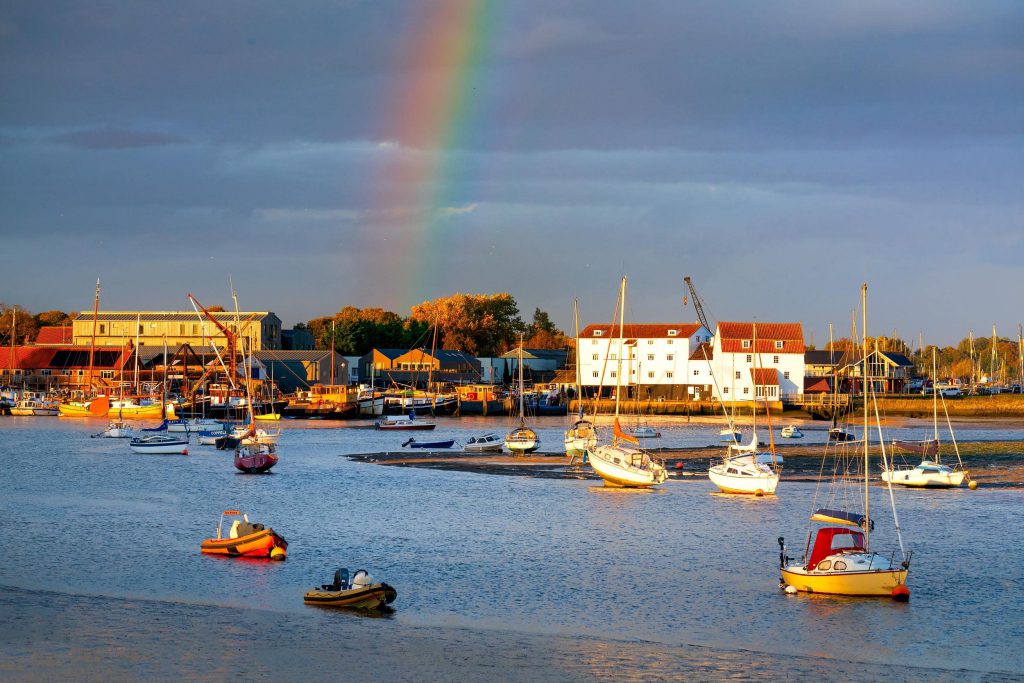 Riverside sunset with a rainbow over boats, Woodbridge, Suffolk, England